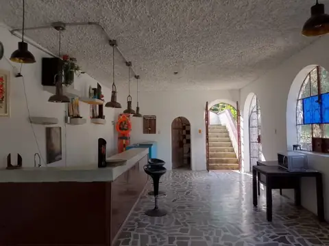 Zona social interior con barra y mesas